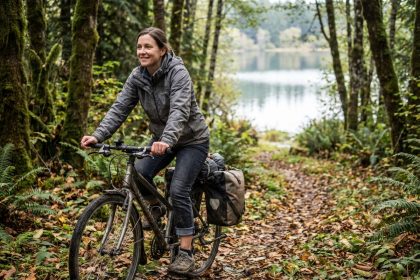 Femme souriante en randonnée à vélo dans la forêt